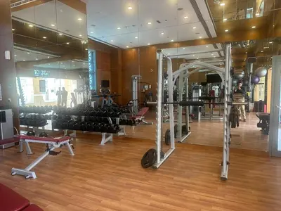 a gym with rows of equipment in a room at Studio with Boulevard View in Dubai