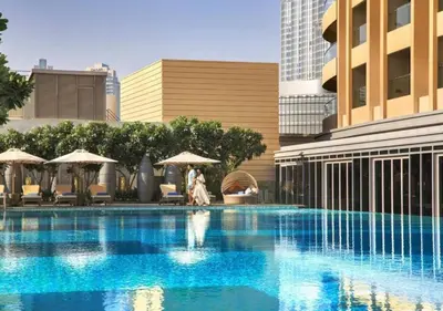 a woman walking by a swimming pool in a city at Fashion Avenue Dubai Mall in Dubai
