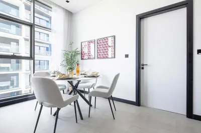 a dining room with a table and chairs and a window at Frank Porter - 15 Northside Tower 2A in Dubai