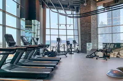 a gym with rows of treadmills and elliptical machines at Frank Porter - 15 Northside Tower 2A in Dubai