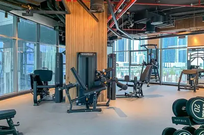 a gym with cardio equipment in a building with windows at Frank Porter - 15 Northside Tower 2A in Dubai