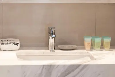 a bathroom counter with a sink and three cups on it at SmartStay at Burj Royale - Full Burj Khalifa View - Brand New Luxury Apartments in Dubai