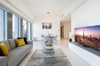 a living room with a couch and a large tv at SmartStay at Burj Royale - Full Burj Khalifa View - Brand New Luxury Apartments in Dubai