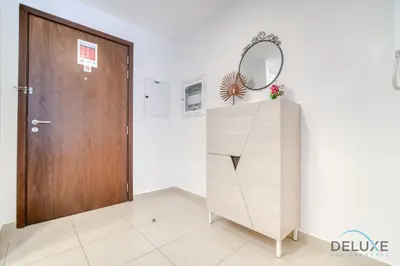 a room with a wooden door and a dresser with a mirror at Soothing 1BR at Safi 1B Town Square Dubailand by Deluxe Holiday Homes in Dubai