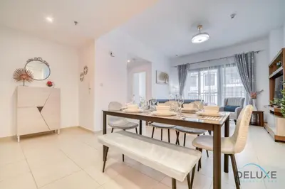 a dining room with a wooden table and chairs at Soothing 1BR at Safi 1B Town Square Dubailand by Deluxe Holiday Homes in Dubai