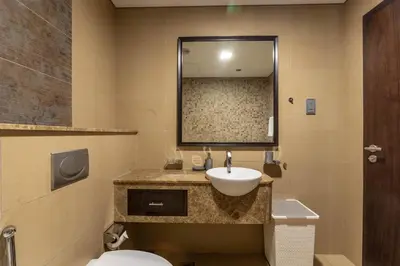 a bathroom with a sink and a toilet and a mirror at Nasma Luxury Stays - White Haven Studio With Charming Cityscape Views in Dubai