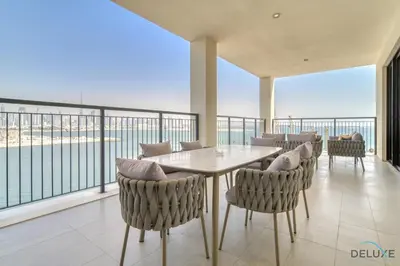 a dining room with a table and chairs on a balcony at Luxurious 4BR Penthouse with Assistant Room and a Sweeping Balcony Showcasing Burj Khalifa and Sea Views, Le Pont, La Mer by Deluxe Holiday Homes in Dubai