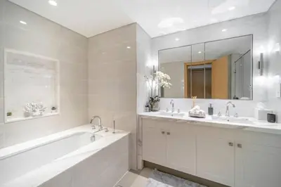 a white bathroom with a tub and two sinks and a bath tub at Luxury 2BR Apartment with Stunning Burj Khalifa & Fountain Views - Opera Grand, Downtown in Dubai