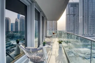 a balcony with two chairs and tables on a balcony at Luxury 2BR Apartment with Stunning Burj Khalifa & Fountain Views - Opera Grand, Downtown in Dubai