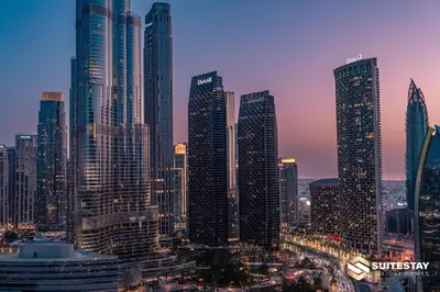 a group of tall buildings in a city at dusk at Fashion avenue Dubai Mall -The Residence in Dubai