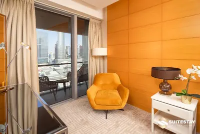 a living room with a chair and a balcony at Fashion avenue Dubai Mall -The Residence in Dubai