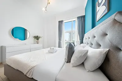 a bedroom with a white bed and a blue wall at 1Br Suit with Full Canal View - Down Town in Dubai