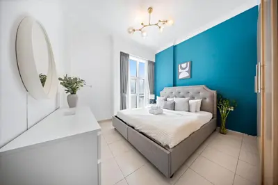 a blue and white bedroom with a bed and a mirror at 1Br Suit with Full Canal View - Down Town in Dubai