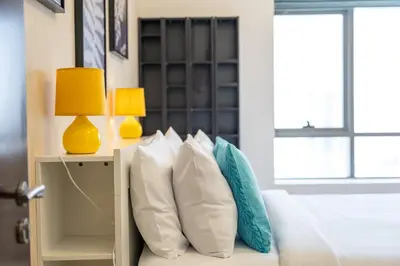 a bedroom with a bed with white pillows and a lamp at Hidden Gem 1 Bedroom apt in Dubai Sport City in Dubai