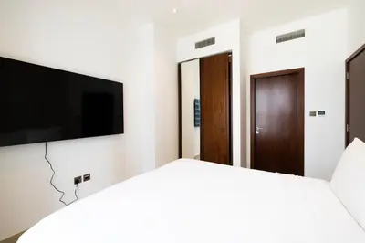 a bedroom with a flat screen tv and a bed at Marina Gate One Bedroom Apartment in Dubai