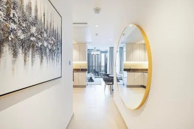 a mirror on a wall in a room with a hallway at Marina Gate One Bedroom Apartment in Dubai