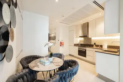 a kitchen and dining room with a table and chairs at Marina Gate One Bedroom Apartment in Dubai