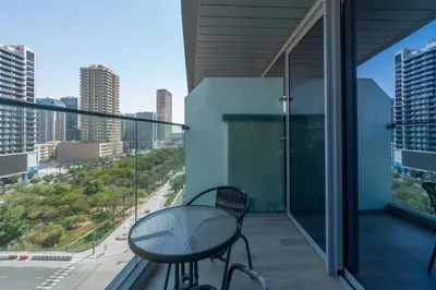 a balcony with a table and a view of a city at Studio in JVC - Heart of Dubaï - Bloom Height in Dubai