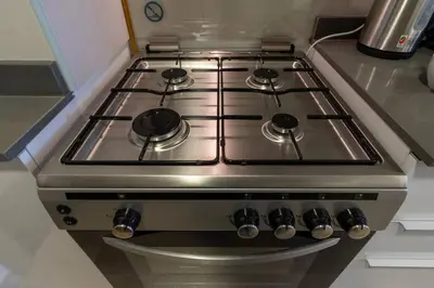 a stainless steel stove top oven in a kitchen at Studio in JVC - Heart of Dubaï - Bloom Height in Dubai