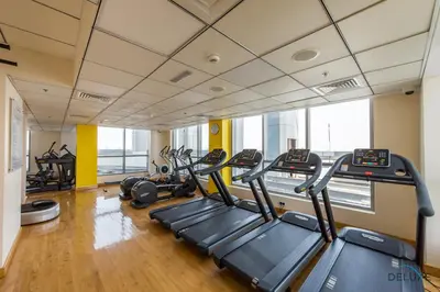 a gym with treadmills and ellipticals in a building at Scenic 1BR at Bay Central 1 Dubai Marina by Deluxe Holiday Homes in Dubai