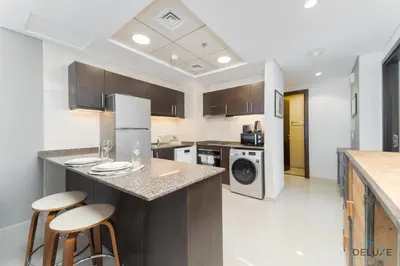 a kitchen with a counter and two bar stools at Scenic 1BR at Bay Central 1 Dubai Marina by Deluxe Holiday Homes in Dubai