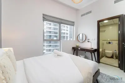 a white bedroom with a bed and a bathroom at Scenic 1BR at Bay Central 1 Dubai Marina by Deluxe Holiday Homes in Dubai