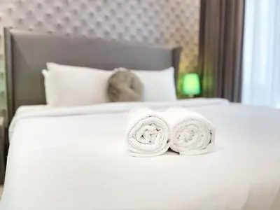 a white bed with two towels on top of it at RH- City Living in Style, Large 1 BR with open Terrace, Dubai Marina in Dubai