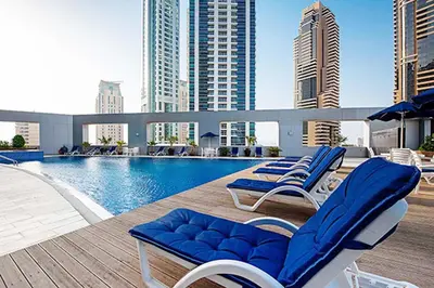 a swimming pool with lounge chairs on the roof of a building at RH- City Living in Style, Large 1 BR with open Terrace, Dubai Marina in Dubai