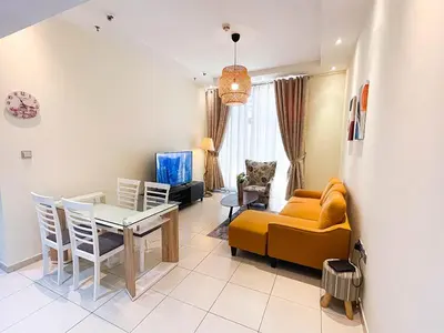 a living room with a yellow couch and a table at RH- City Living in Style, Large 1 BR with open Terrace, Dubai Marina in Dubai