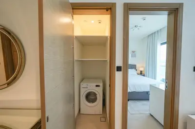 a laundry room with a washer and dryer at Bright Apartment With Panoramic CityScape Views in Dubai