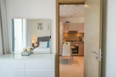 a view of a kitchen and a living room at Bright Apartment With Panoramic CityScape Views in Dubai