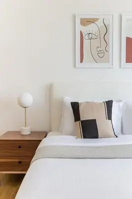 a white bed with pillows and a lamp on a table at Frank Porter - Bonaire Tower in Dubai