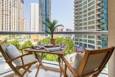 a table and chairs on a balcony with a view of a city at Frank Porter - Bonaire Tower in Dubai