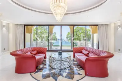 a living room with two red couches and a table at Staycae Palm Jumeirah Villa in Dubai