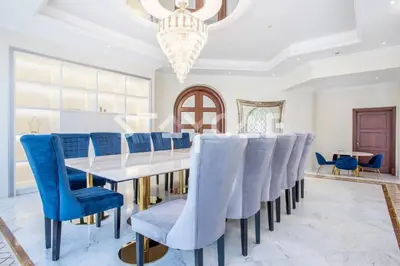 a dining room with a table and blue chairs at Staycae Palm Jumeirah Villa in Dubai