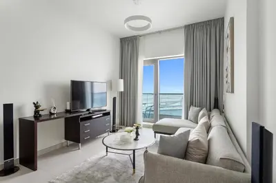 a living room with a couch and a tv at Spacious 1 bedroom in Business Bay - Close to Downtown in Dubai