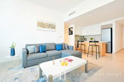 a living room with a couch and a table at LUX The Dubai Creek View Suite in Dubai