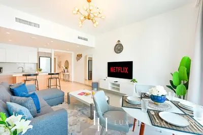 a living room with a couch and a table at LUX The Dubai Creek View Suite in Dubai