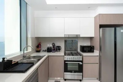 a kitchen with a sink and a stove top oven at 2bdr Emaar The Grand - Sea View - Creek Harboor in Dubai