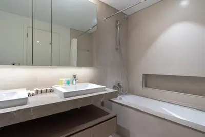 a bathroom with two sinks and a tub and a mirror at 2bdr Emaar The Grand - Sea View - Creek Harboor in Dubai