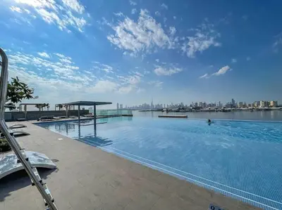 a large swimming pool with a view of the city at 2bdr Emaar The Grand - Sea View - Creek Harboor in Dubai
