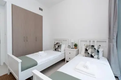 two beds in a small room with white and green at 2bdr Emaar The Grand - Sea View - Creek Harboor in Dubai