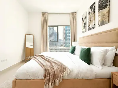 a bedroom with a large white bed with a window at Trophy - Downtown Skyline Sanctuary Suite in Dubai