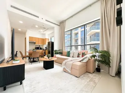 a living room with a couch and a large window at Trophy - Downtown Skyline Sanctuary Suite in Dubai