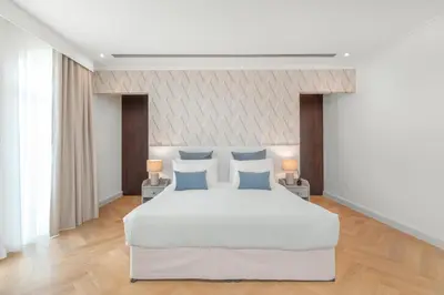a bedroom with a large white bed with blue pillows at Private villa in Dubai with swimming pool and huge garden in Dubai