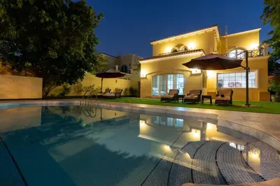 a swimming pool in front of a house at Private villa in Dubai with swimming pool and huge garden in Dubai