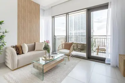 a living room with a couch and a glass table at Frank Porter - Creekside 18 in Dubai