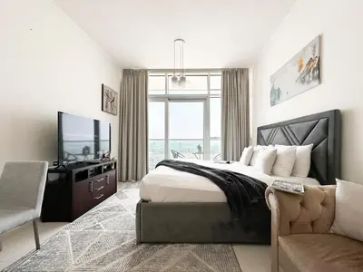 a bedroom with a bed and a tv and a couch at Trophy - Urban Escape Suite in Dubai
