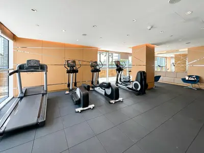 a gym with treadmills and ellipticals in a room at Trophy - Urban Escape Suite in Dubai