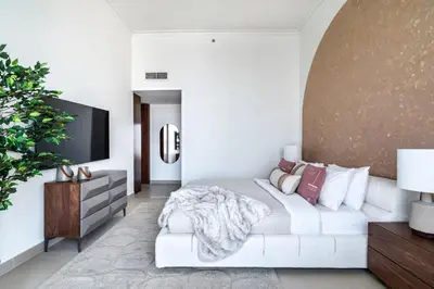 a living room with a white couch and a tv at The Smart Concierge - Burjvista in Dubai